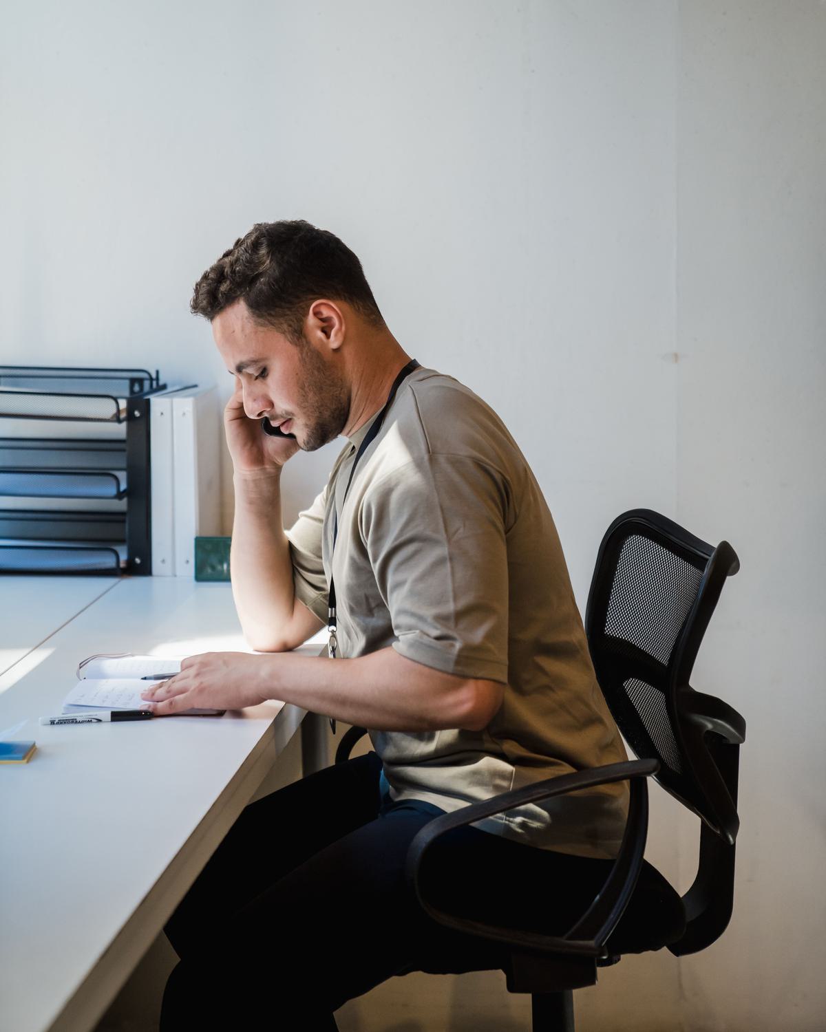 An office worker checking orders on a screen next to the warehouse floor