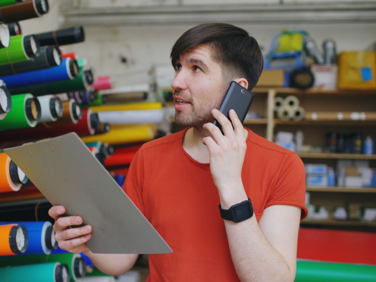 A sales desk employee on the phone in a warehouse office